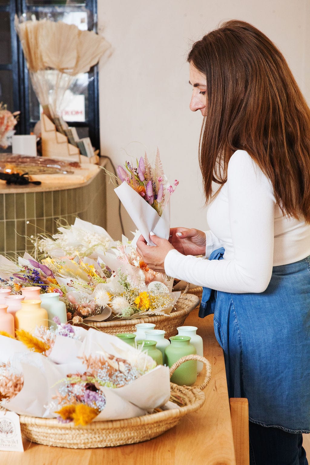 Woman arranging flowers in a store setting