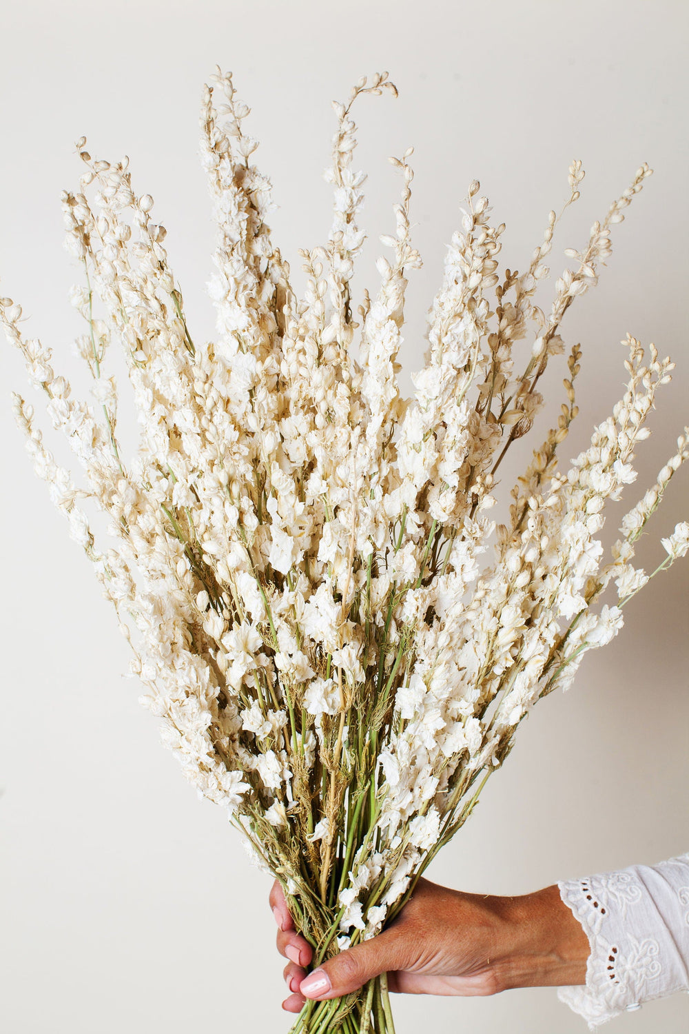Small White Dried Flowers In Beige Wicker Basket And Wooden Decor
